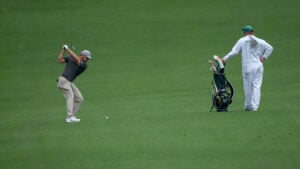 golfspelaren bryson dechambeau på golfbanan augusta national golf club med sin caddie iklädd vit overall