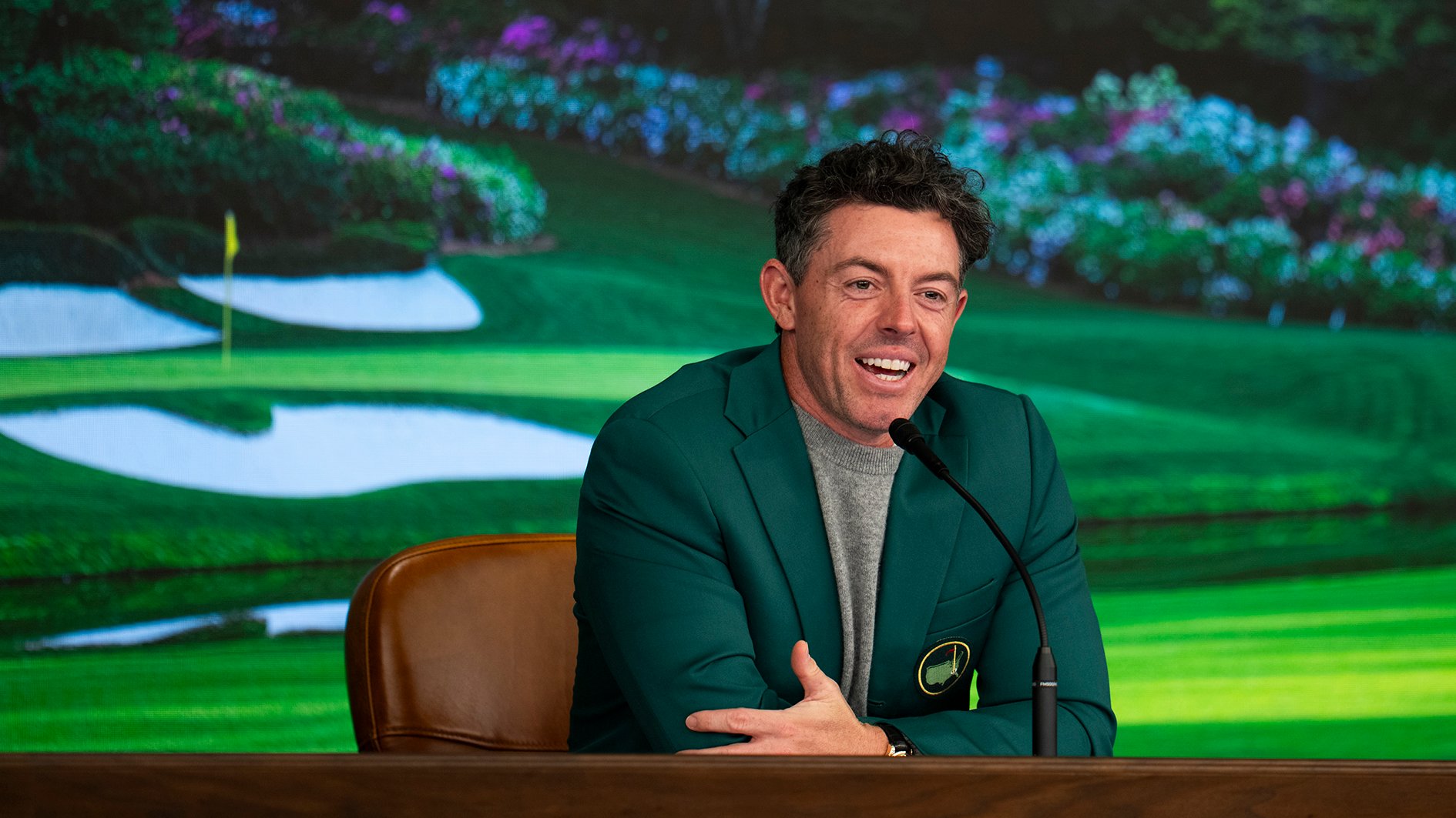 golfspelaren rory mcilroy i grön kavaj på ett podium