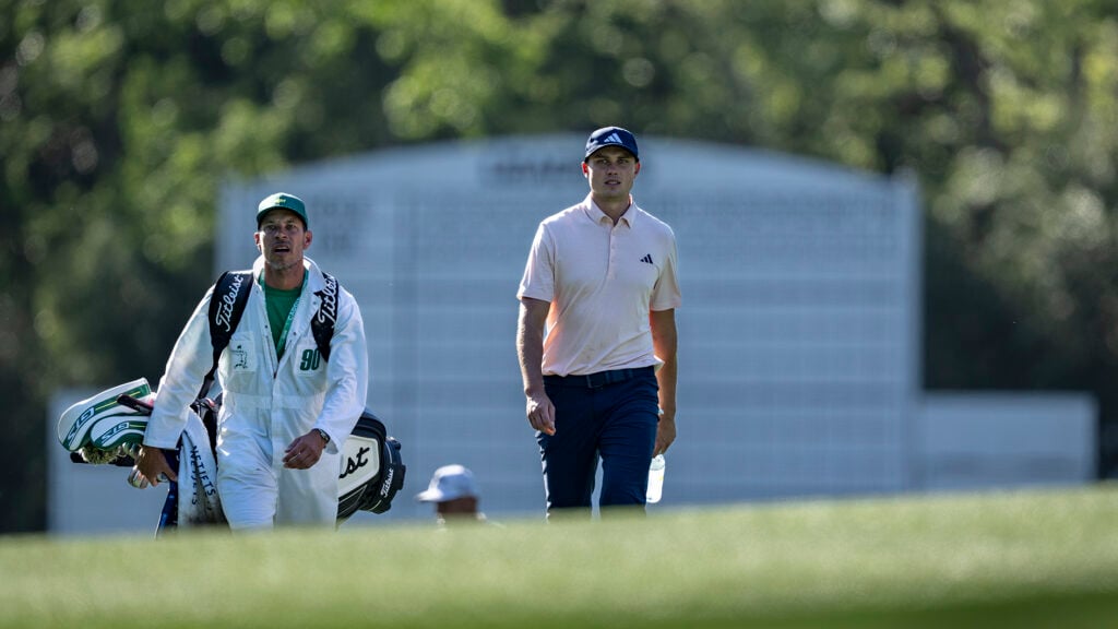 golfspelaren ludvig åberg promenerar på en golfbana med sin caddie joe skovron iklädd vit overall