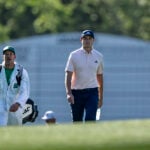 golfspelaren ludvig åberg promenerar på en golfbana med sin caddie joe skovron iklädd vit overall