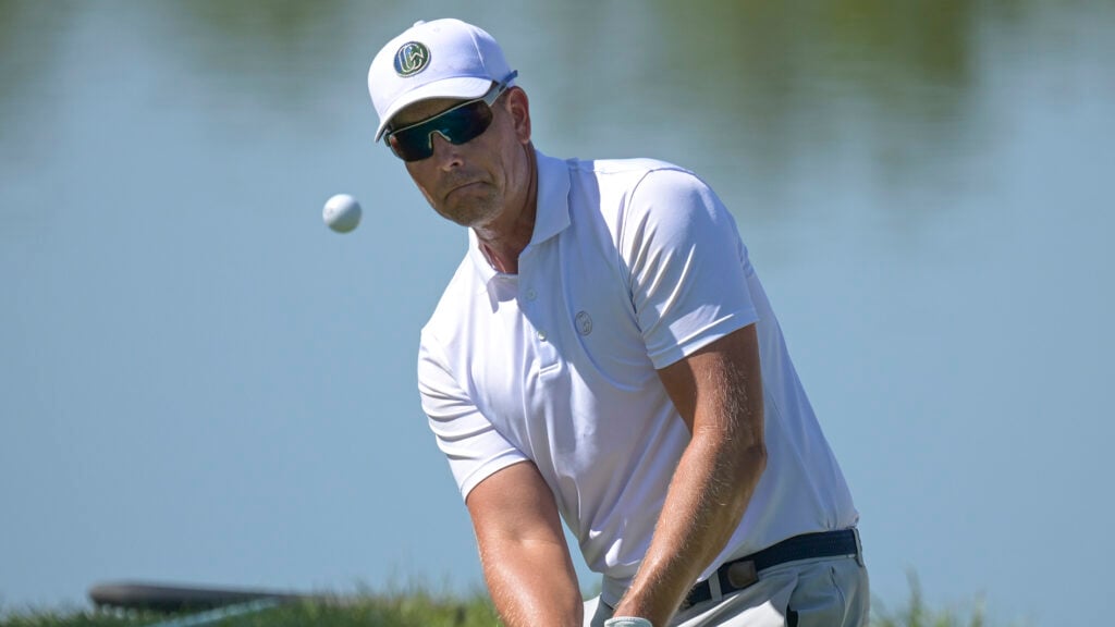 golfspelare henrik stenson chippar och följer bollen i luften