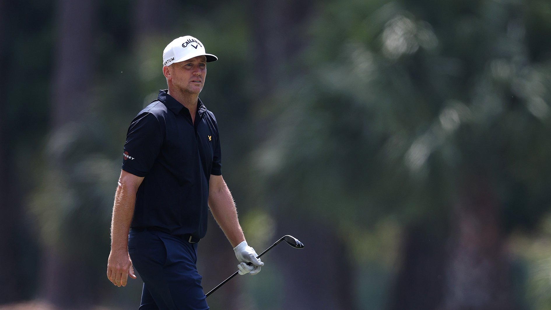 golfspelaren alex noren i vit golfkeps och svarta golfkläder på en golfbana