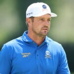 golfspelaren bryson dechambeau i vit golfkeps och blå golfpiké