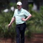 golfspelare med randig golfpiké på golfbana