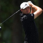 golfspelaren ludvig åberg iklädd svarta golfkläder svingar en driver på en golfbana