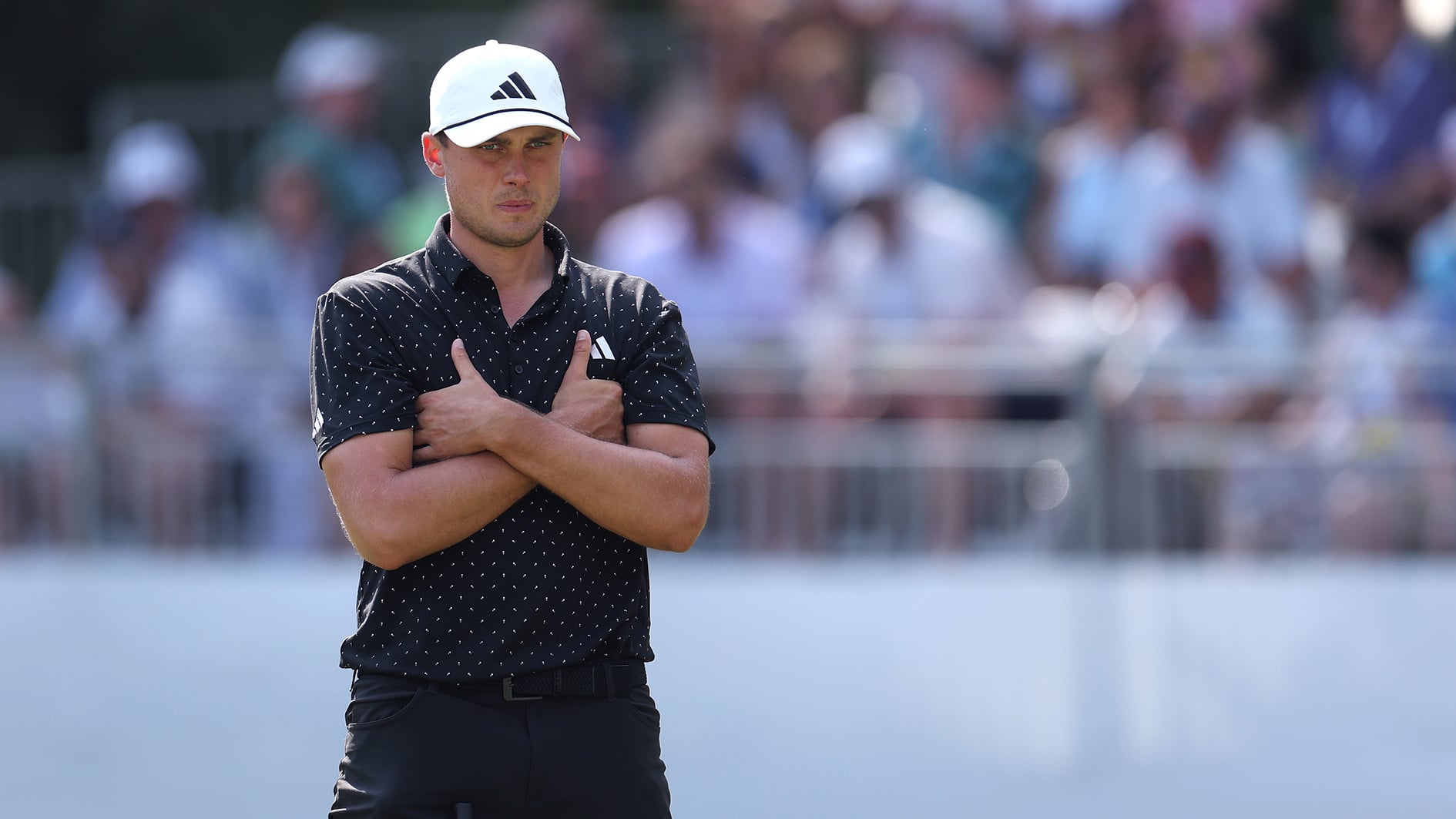 golfspelaren ludvig åberg med armarna i kors på en golfbana