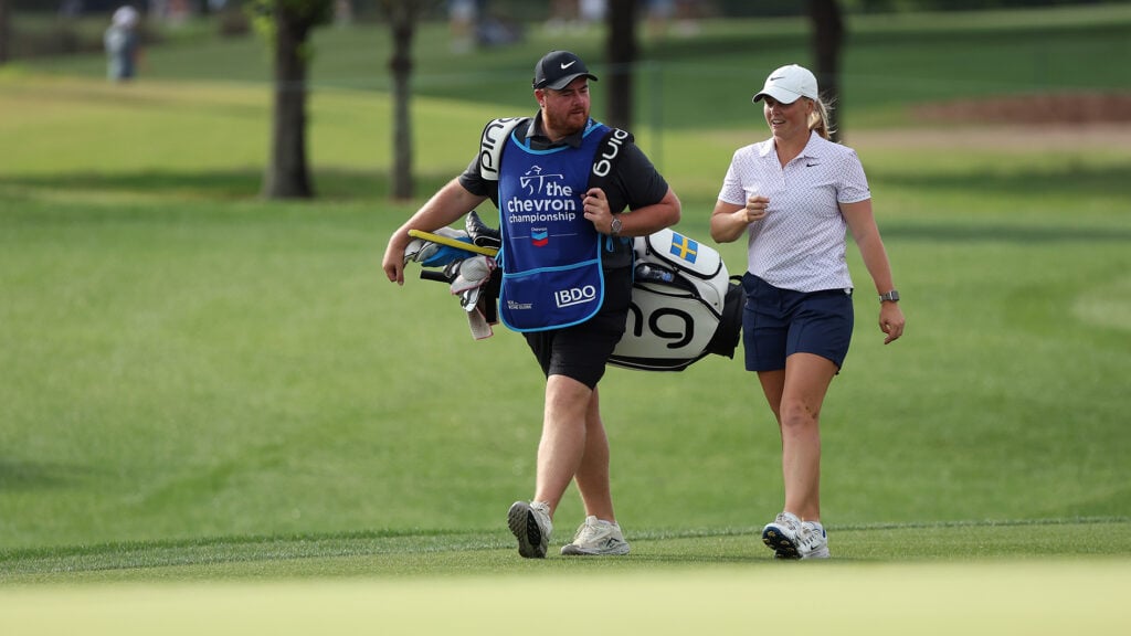 golfspelar och caddie på golfbana