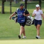 golfspelar och caddie på golfbana