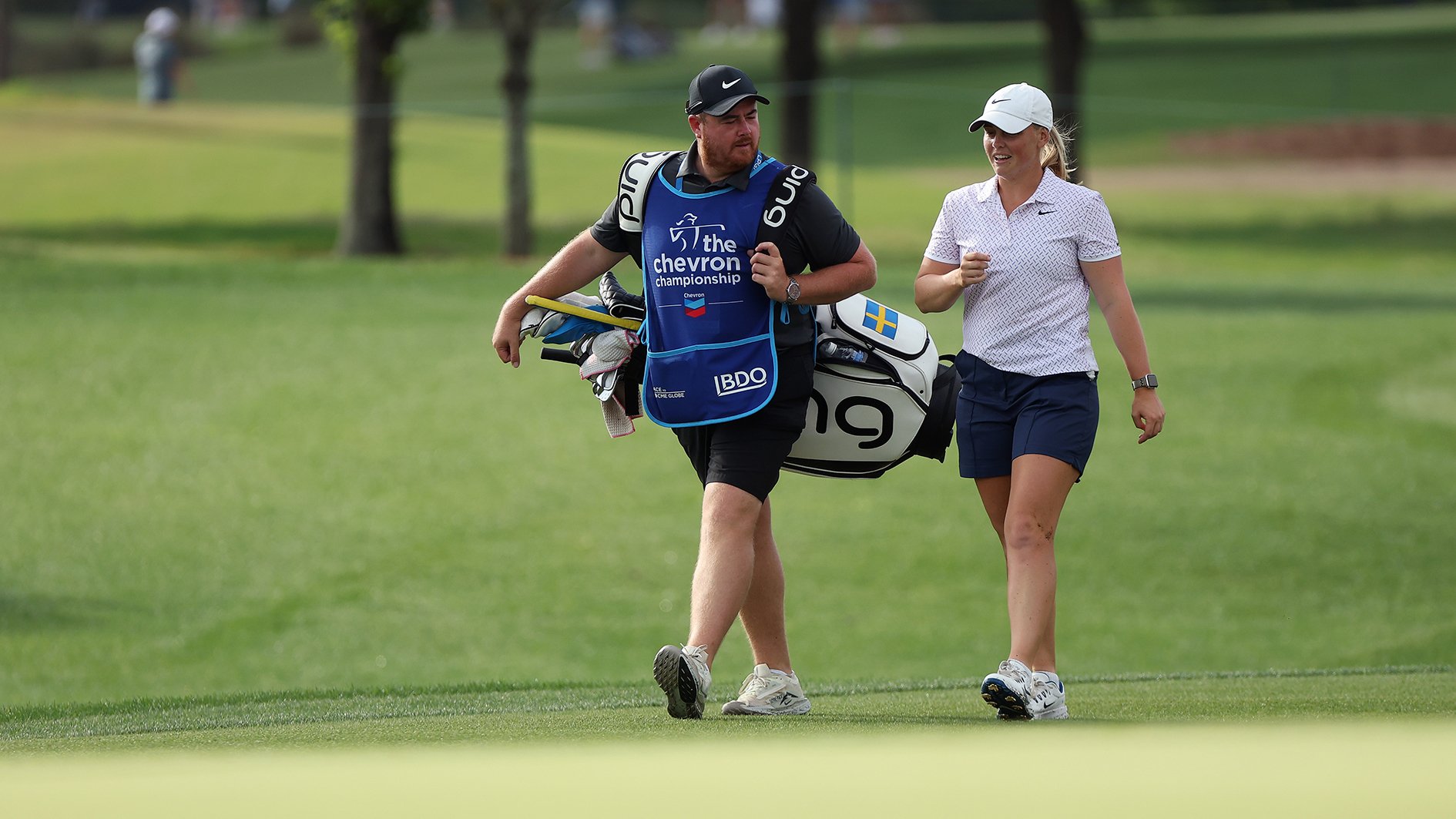 golfspelar och caddie på golfbana