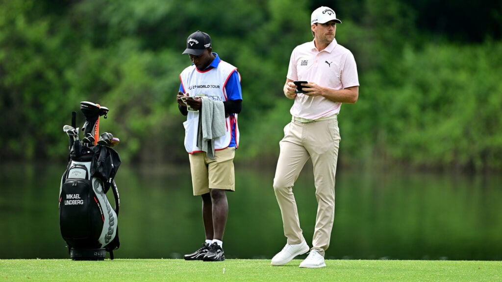 golfbag, caddie och golfspelare på golfbana