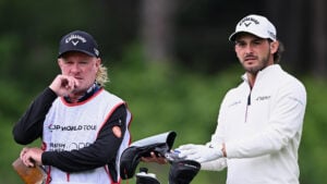 golfspelare, caddie och golfklubbor på golfbana