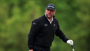 golfspelare i svarta golfkläder på en golfbana