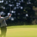 golfspelaren alex norén slår ett golfslag så att gräs yr