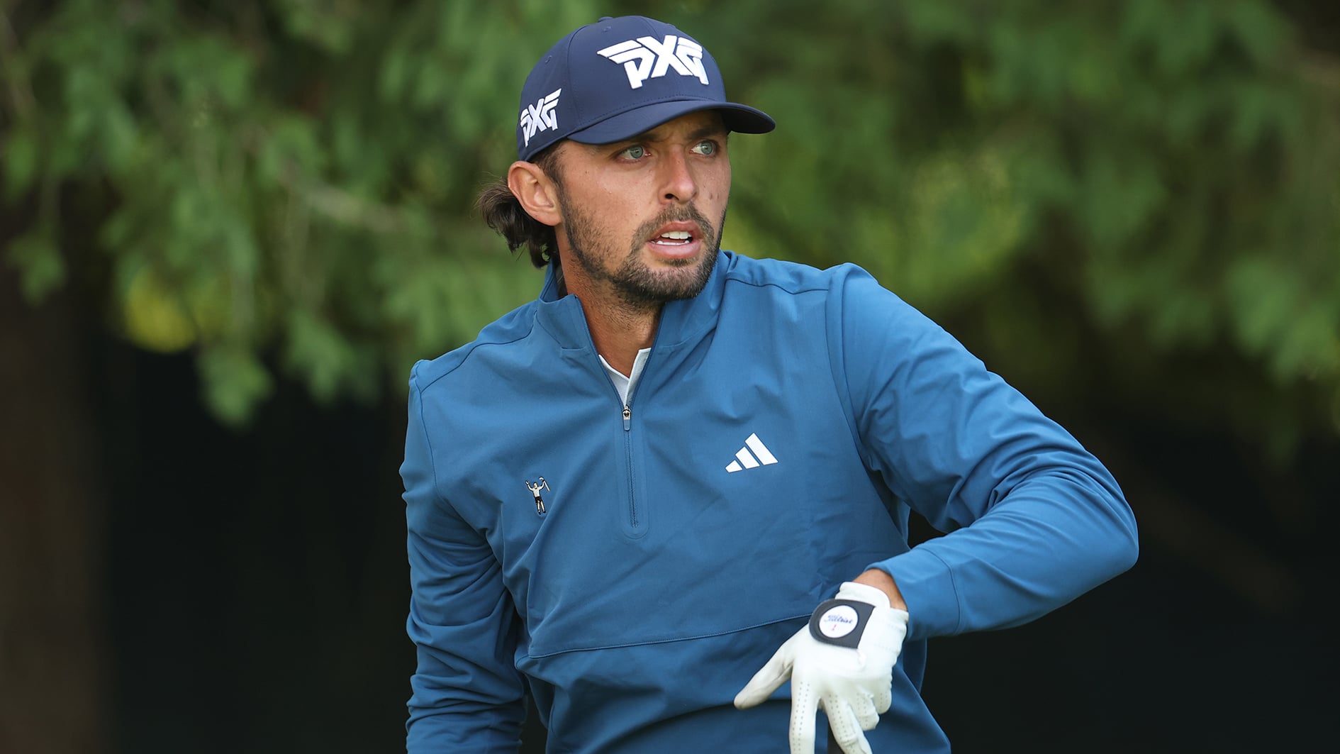 golfspelare i blå golftröja och svart golfkeps