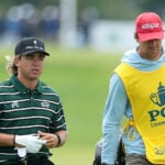 golfspelare och caddie på golfbana under proffstävling