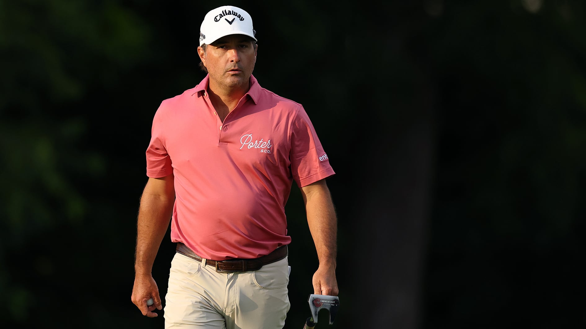 golfspelare med vit golfkeps och rosa golfpiké