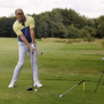 golftränare visar hur man ska slå med en driver