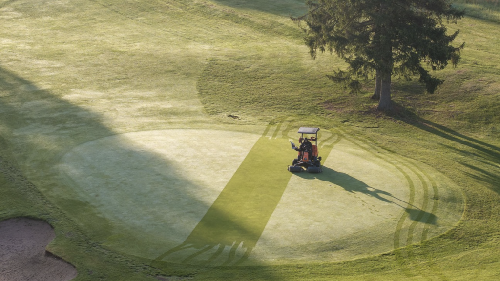 åkgräsklippare klipper green i dagg på golfbana i sverige