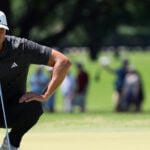 golfspelaren ludvig åberg i svarta golfkläder läser en puttlinje på en golfgreen under en golftävling i usa