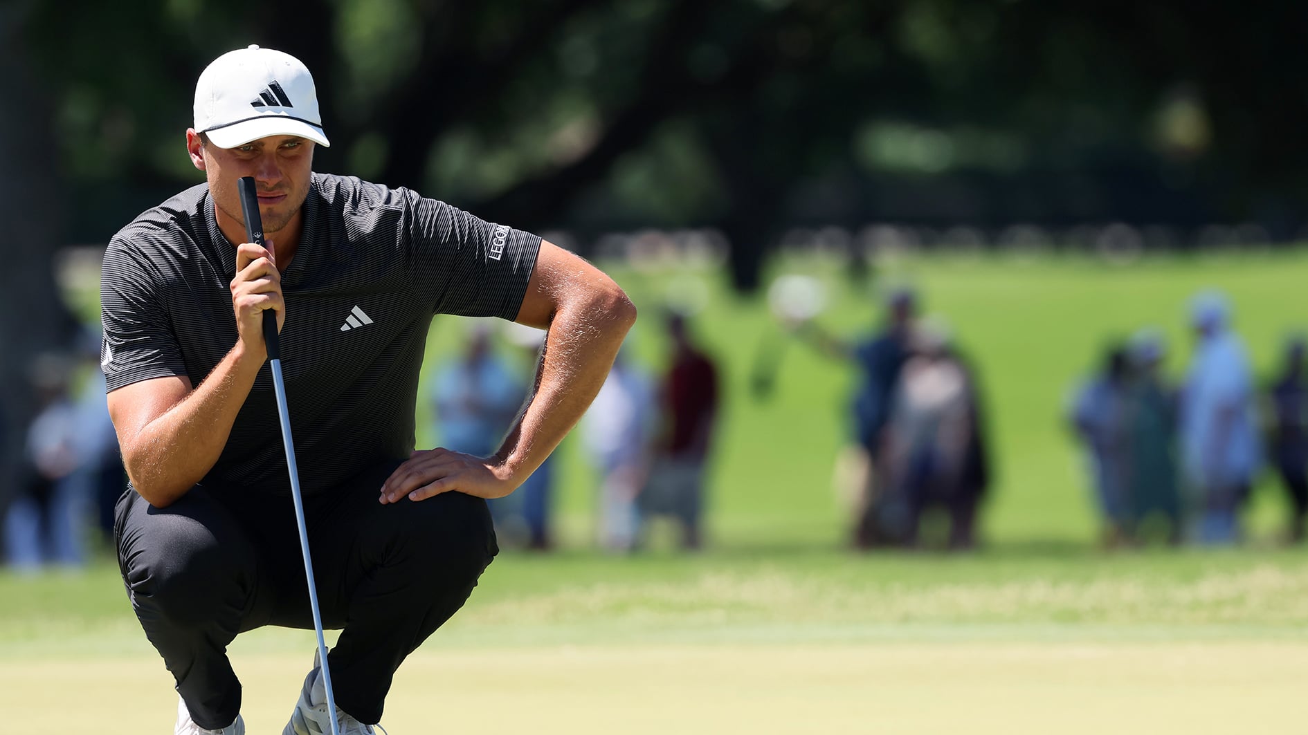 golfspelaren ludvig åberg i svarta golfkläder läser en puttlinje på en golfgreen under en golftävling i usa