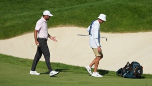 golfspelare och caddie på golfbana under golftävling