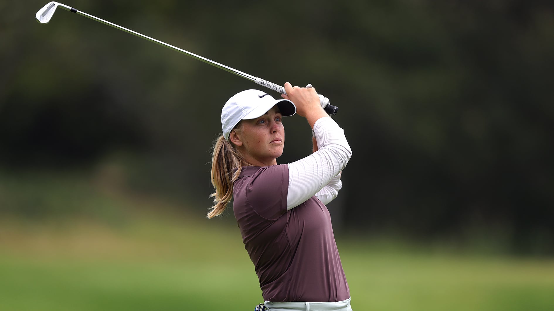 golfspelaren maja stark slår ett järnslag på en golfbana i usa