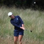 golfspelare slår golfslag från högt gräs på golfbana