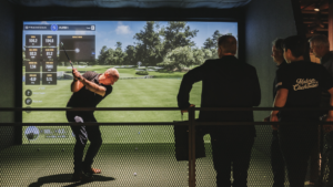 män spelar golf inomhus