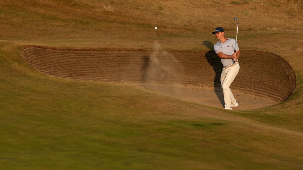 justin rose slår ett golfslag ur en sandbunker på en golfbana