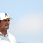 golfspelare i vit golfkeps och vit golfpiké