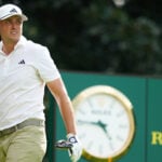 ludvig åberg tittar på golfslag på golfbana med klocka i bakgrunden