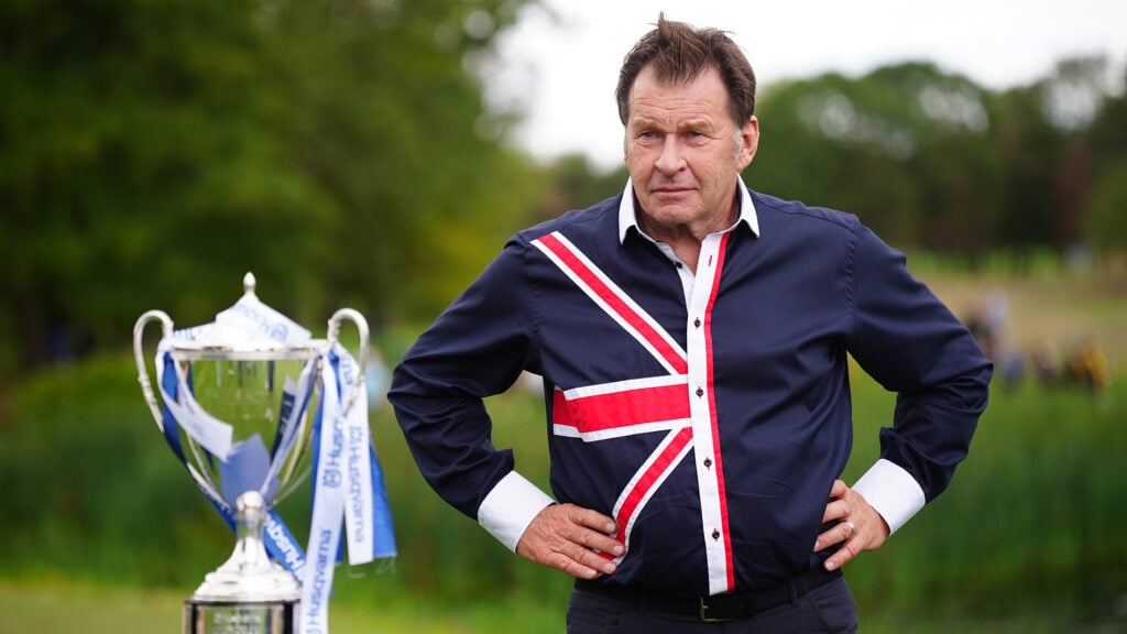 golfspelaren sir nick faldo och en stor pokal på en golfbana