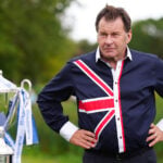golfspelaren sir nick faldo och en stor pokal på en golfbana