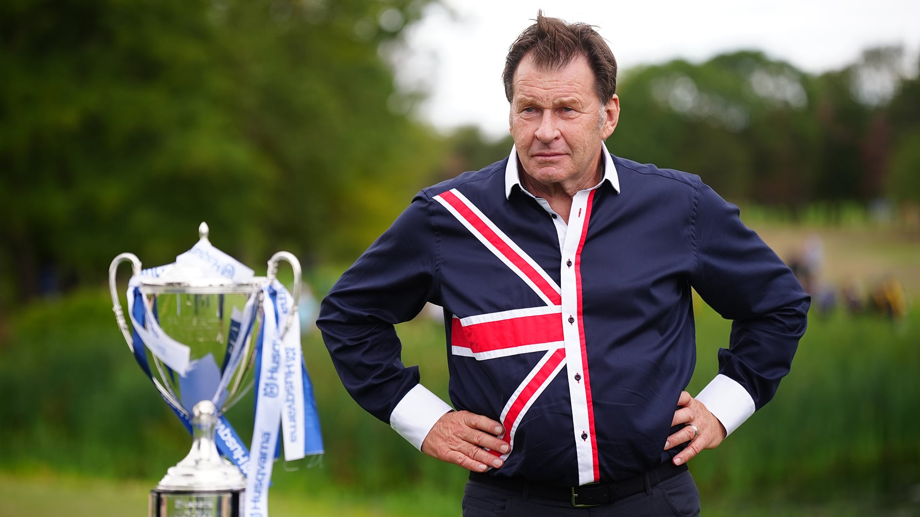 golfspelaren sir nick faldo och en stor pokal på en golfbana