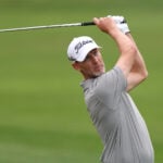 golfspelar med vit golfkeps på grön golfbana