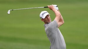 golfspelar med vit golfkeps på grön golfbana