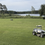 robotar klipper gräs på golfbana.