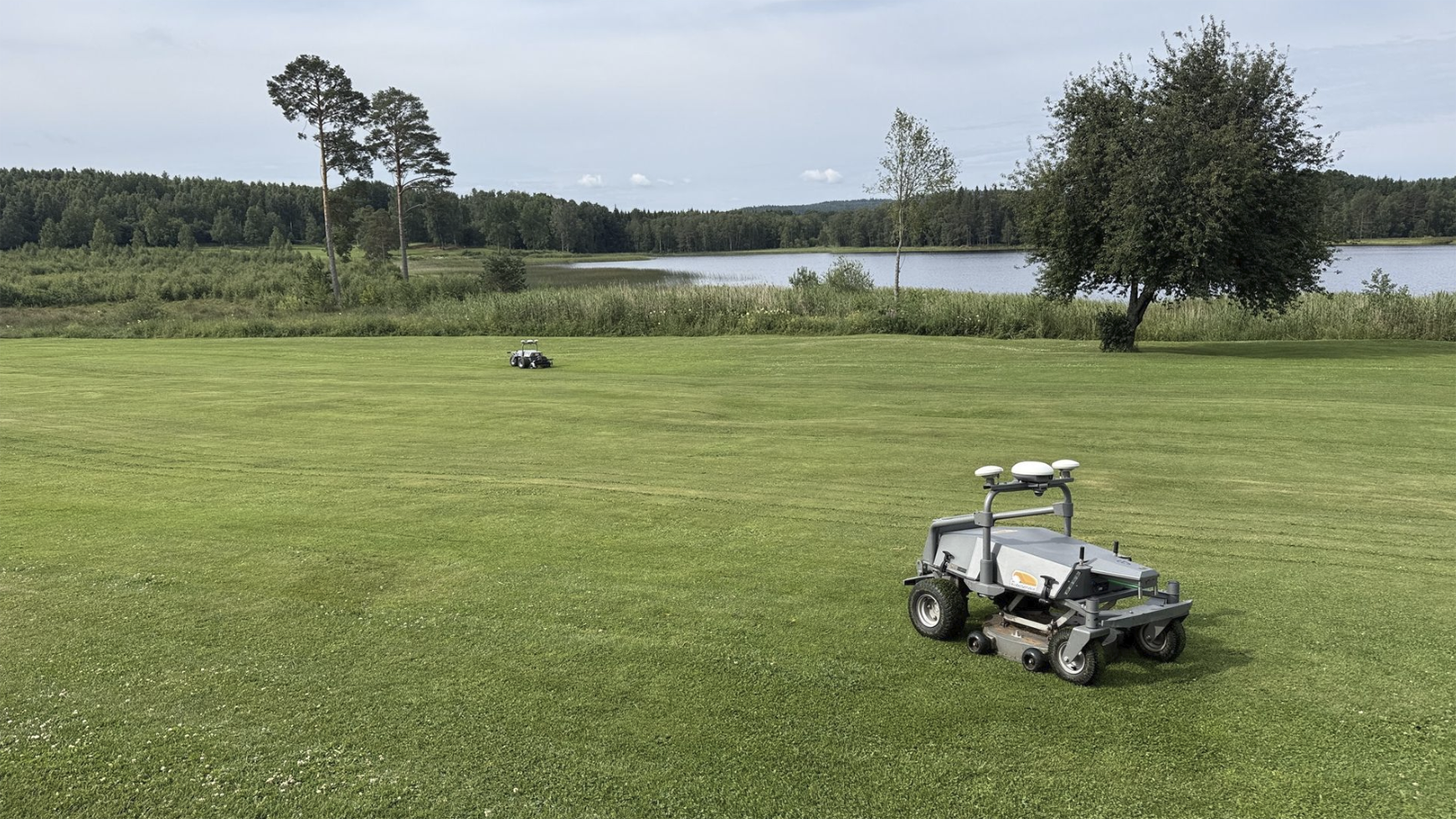 robotar klipper gräs på golfbana.