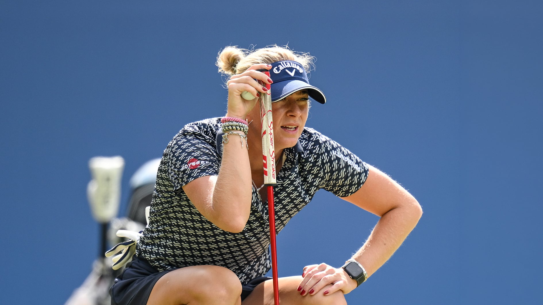 golfspelaren Louise Rydqvist läser puttlinje på golfgreen