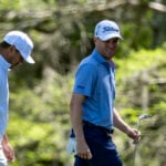 golfspelare promenerar på golfbana med många lövträd