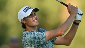 golfspelare i vit golfkeps och mönstrad golfpiké
