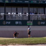 golfspelar och caddie på golfbana i saudiarabien