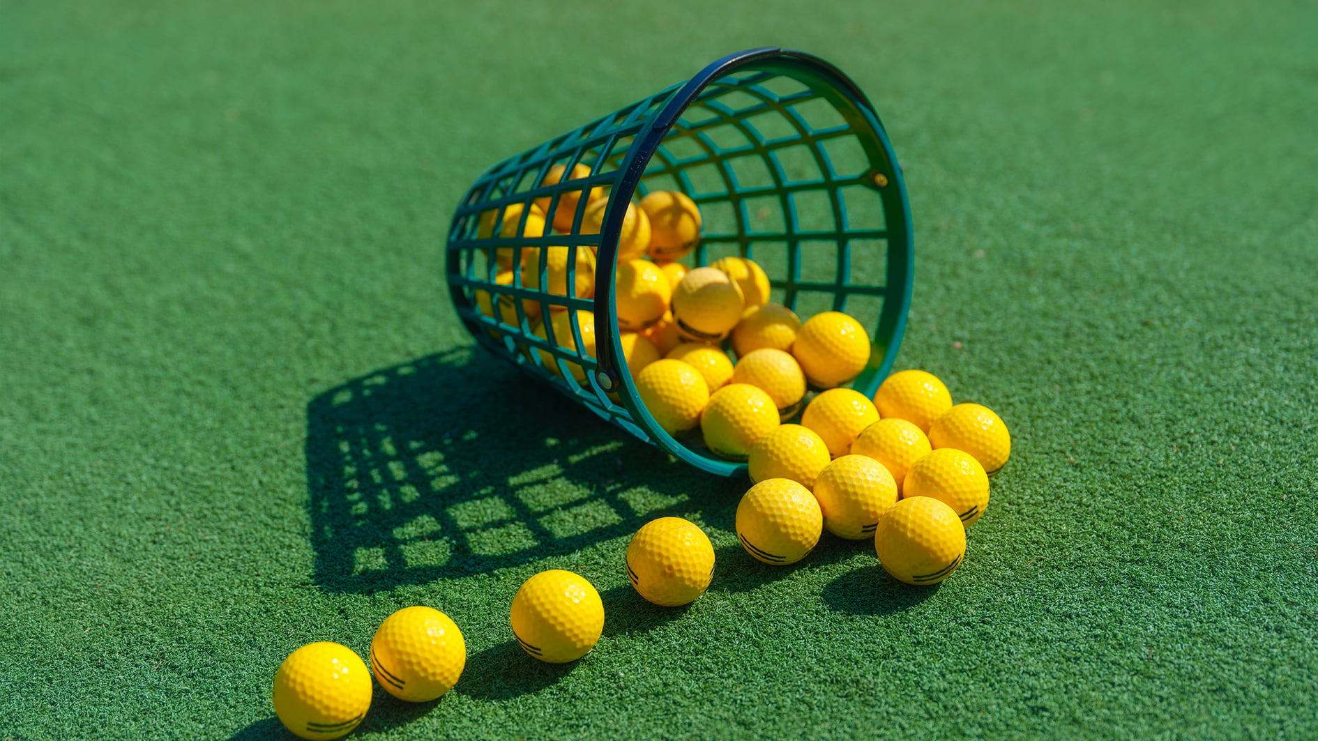 gula golfbollar, grön hink på grönt konstgräs