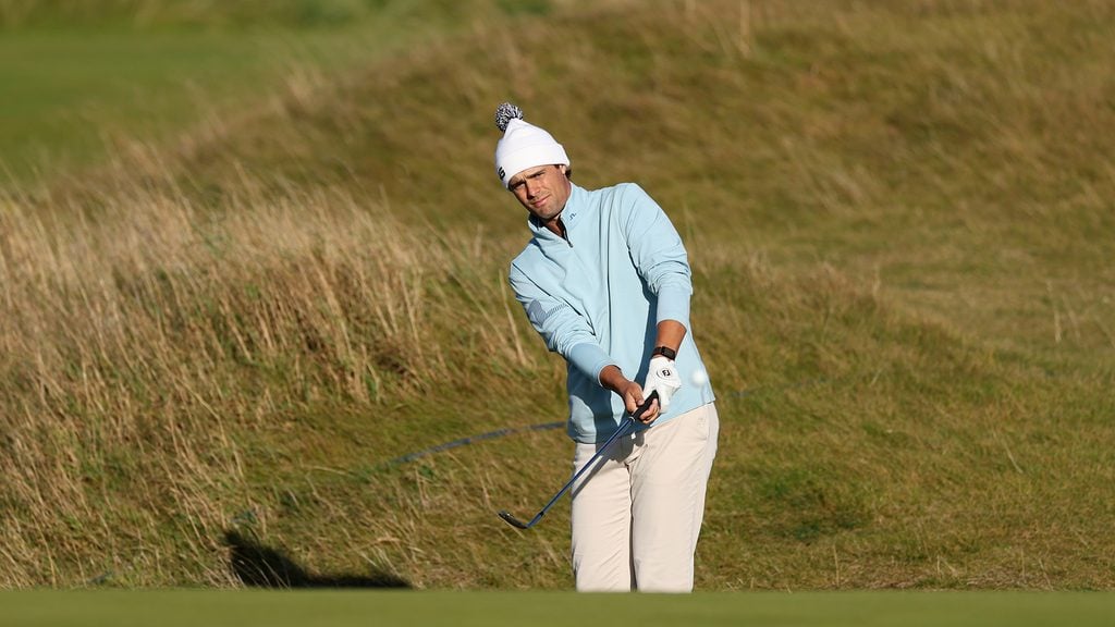 golfspelare slår golfslag från högt gräs på golfbana