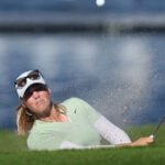 golfspelare slår bunkerslag på golfbana