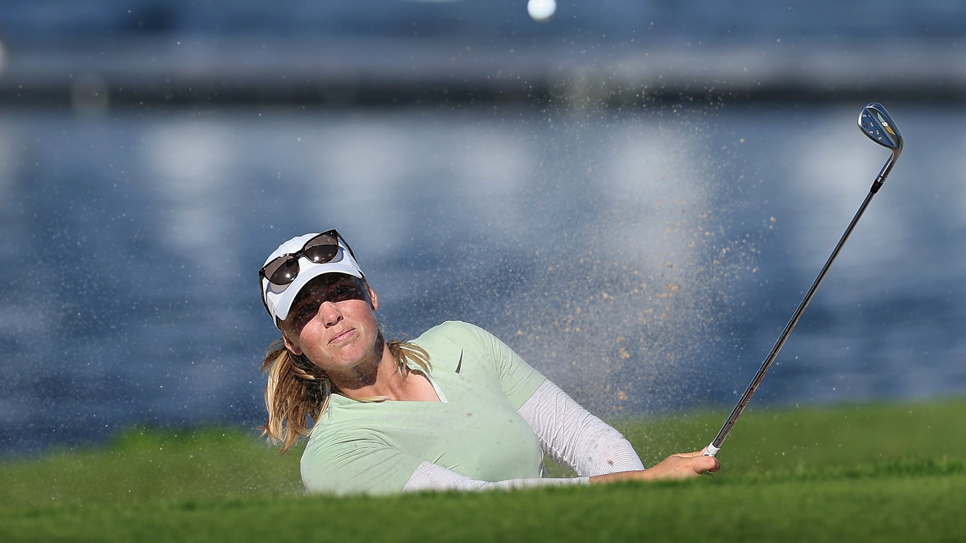 golfspelare slår bunkerslag på golfbana