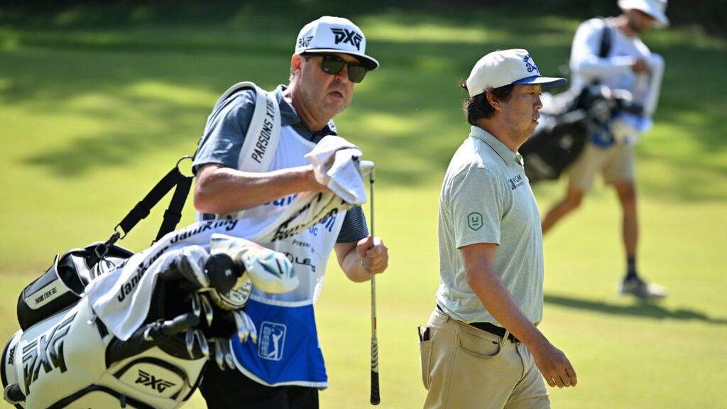 caddie och golfspelare på golfbana