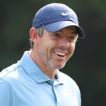 golfspelaren rory mcilroy i blåa golfkläder skrattar på en golfbana