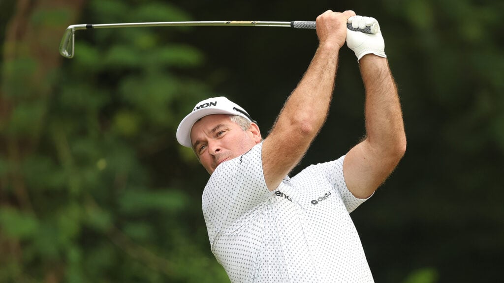 golfspelare svingar golfklubba på golfbana