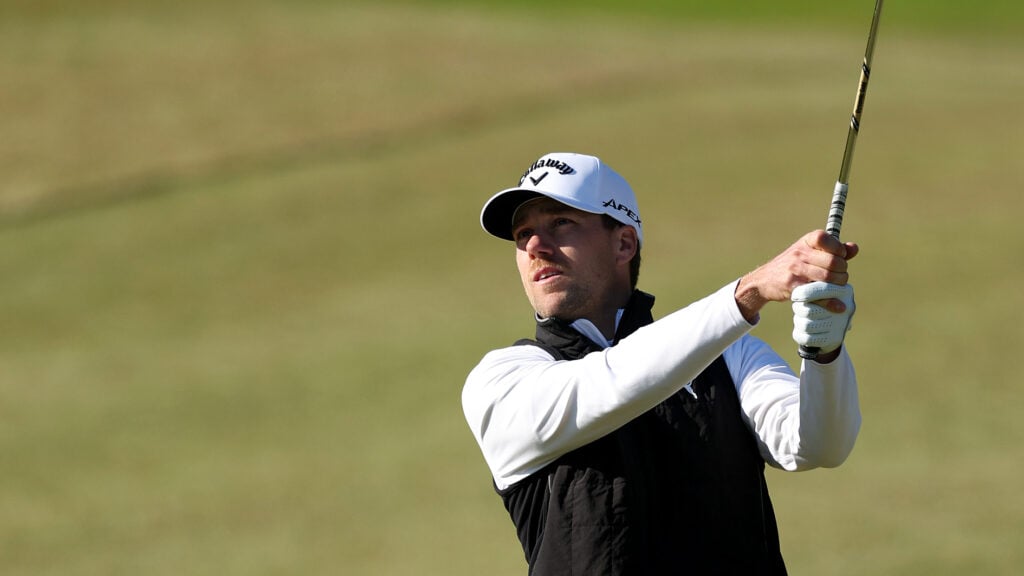 golfspelare i varma golfkläder på golfbana i sydkorea